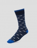 Two pairs of socks, one with navy blue dots and the other with a blue automobile print. 