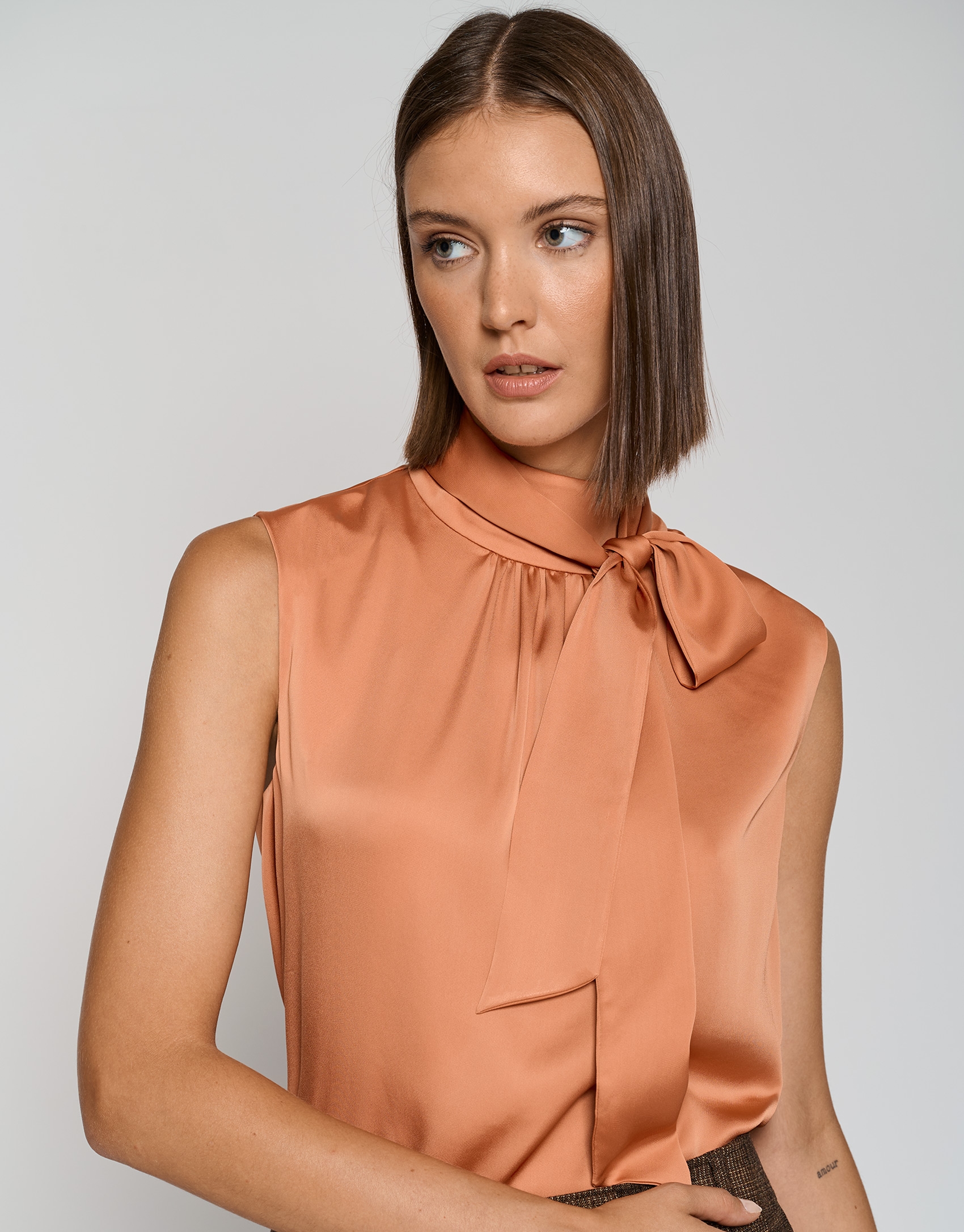 Orange satin knit top with bow